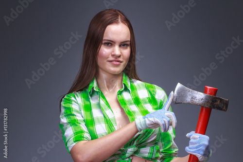 Woman checks how acutely sharpened ax photo