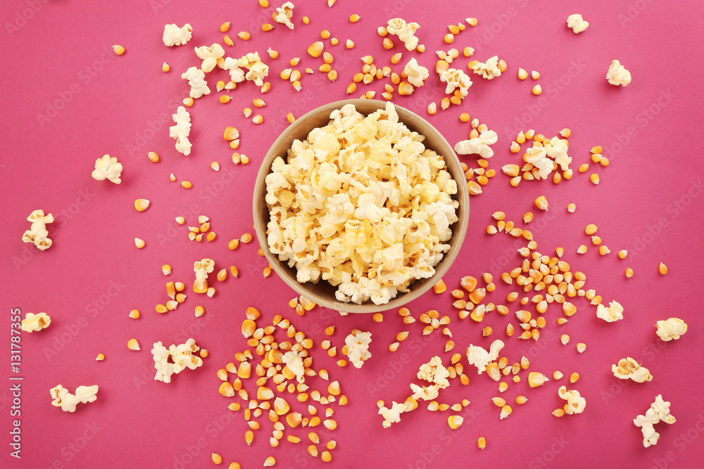 Bowl full of traditional popcorn on pink background Bowl full of traditional popcorn on pink background