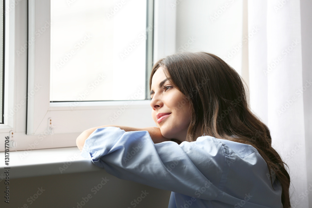 Beautiful woman looking through the window