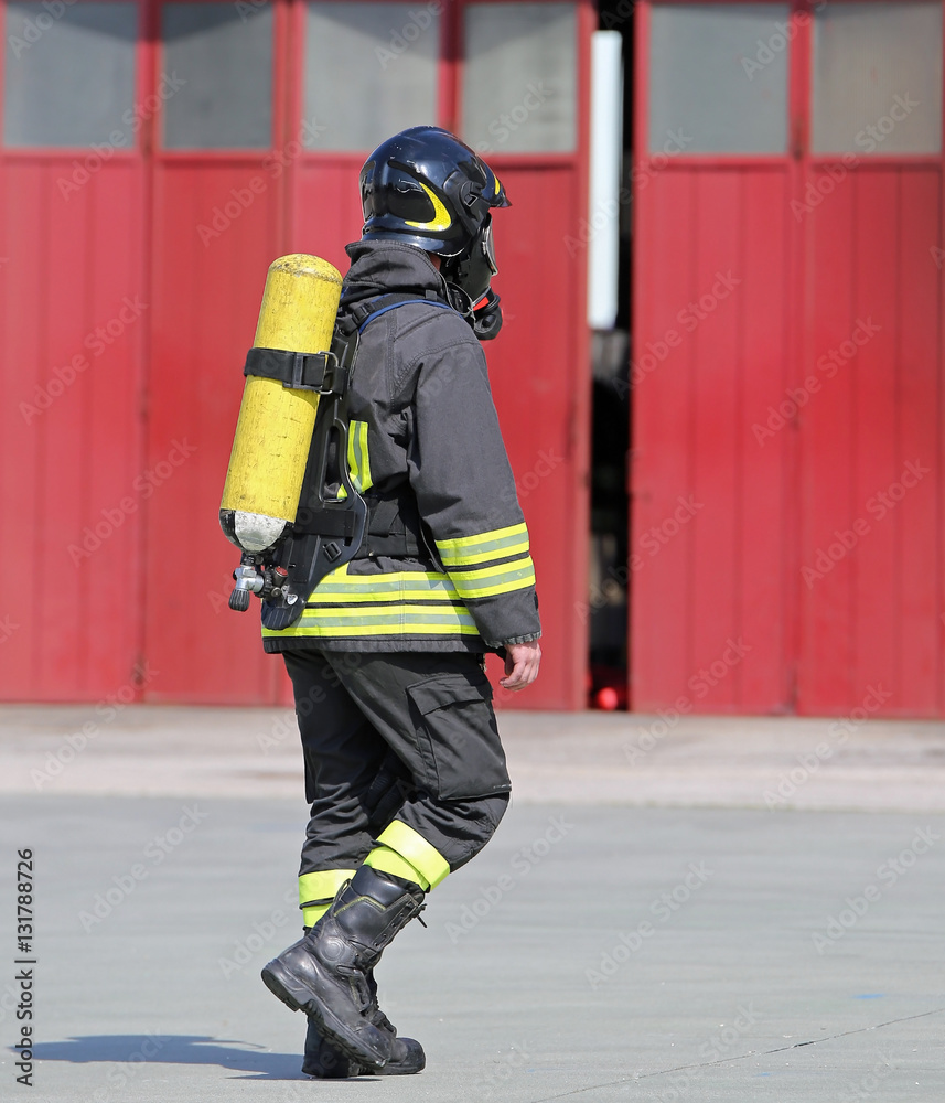 Obraz premium Fireman with oxygen tank to breathe during fire