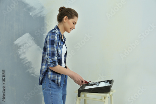 Fotografia Beautiful young woman making repair in room