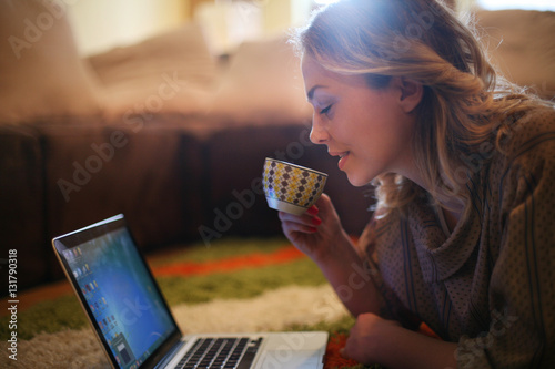 Blonde woman using her laptop at home.