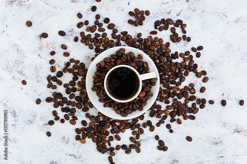 Coffee cup and coffee beans on white background. Top view. Flat lay