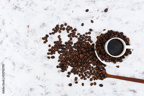 Coffee cup and coffee beans on white background. Top view