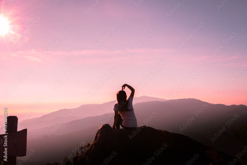 The silhouette of a woman Happy mountain morning sunrise.