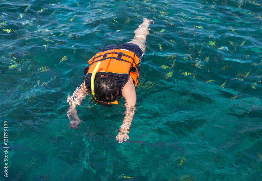 woman snorkeling with life jackets in andaman sea at phi phi islands, Thailand