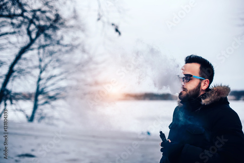 Man with beard vape electronic cigarette outdoor