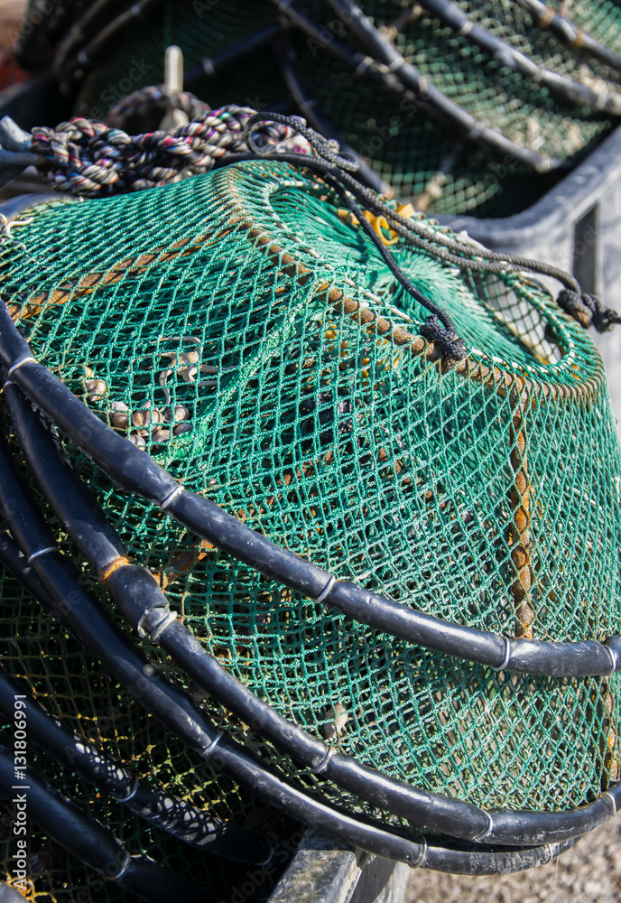  Green fishing creels and net stacked on the fishing port.