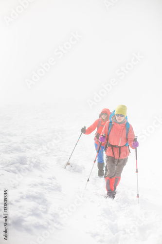 Climbing a mountain during bad weather.