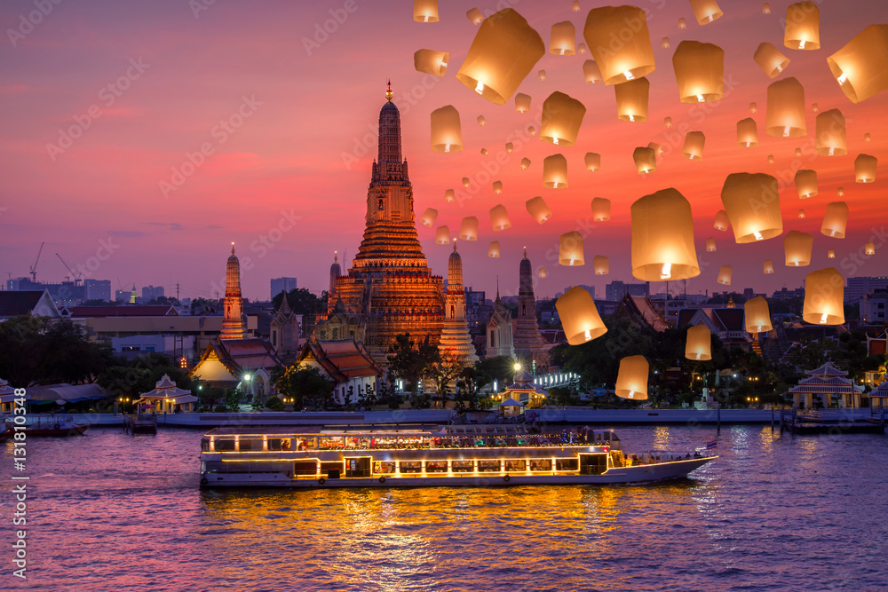 Fototapeta premium Wat arun i statek wycieczkowy w porze nocnej i pływająca lampa podczas festiwalu yee peng w dzień loy krathong, miasto Bangkok, Tajlandia