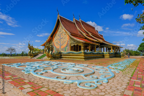 Sirindhorn Wararam Temple (Phu Prao Temple), Ubon Ratchathani, Thailand under the sunlight,  blue sky and white cloud background. © bnoragitt