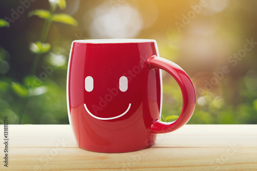 Red mug of coffee with a happy smile
