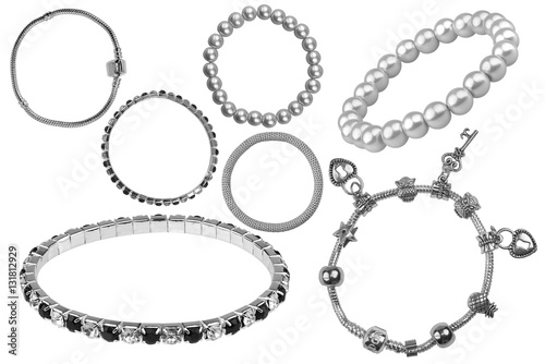 Group of many elegant silver and metallic bracelets, with precious stones and little charms, isolated on white background, clipping paths included