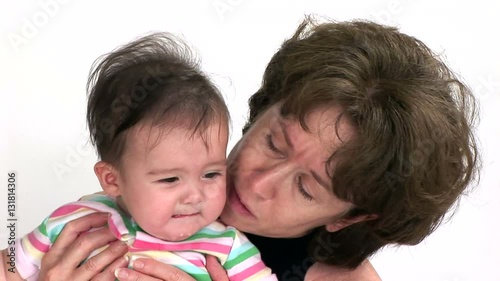 A grandmother holding her granddaughter who is becoming fussy and unhappy. photo