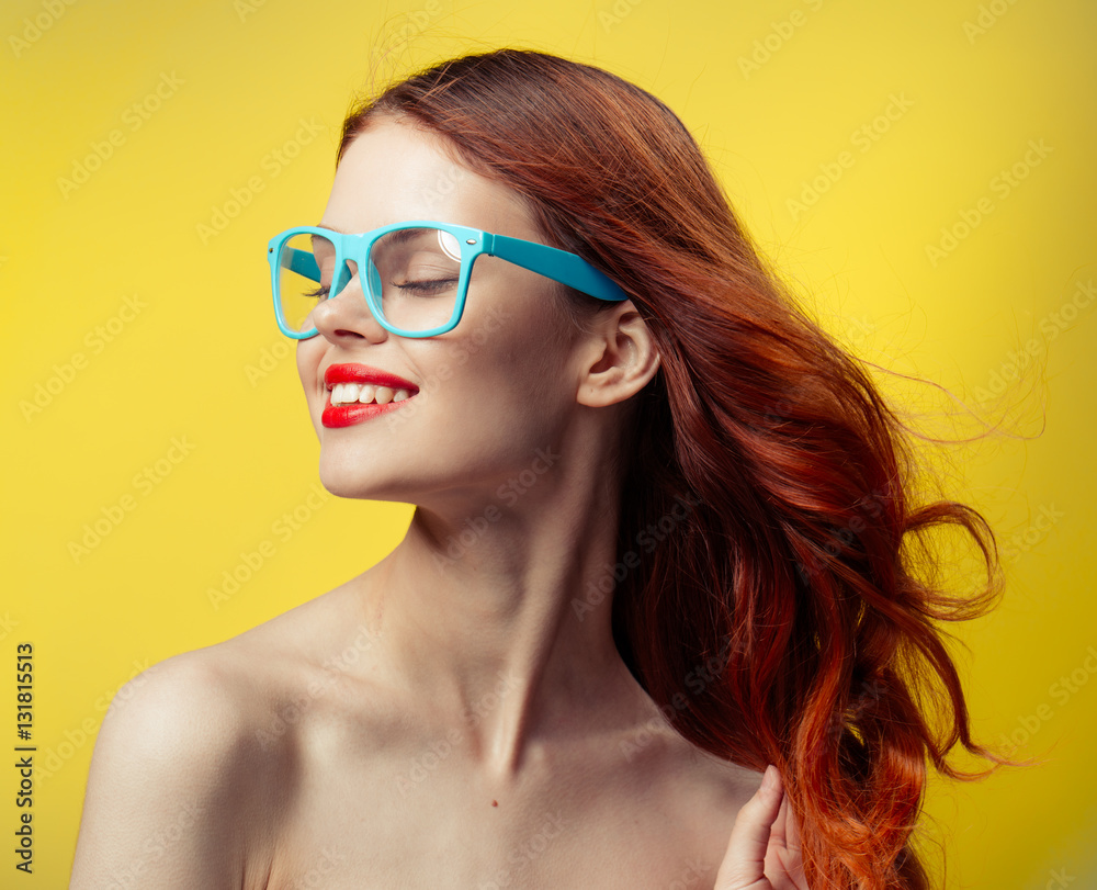 red-haired woman in glasses with a blue rim on a yellow background red-haired woman in glasses with a blue rim on a yellow background