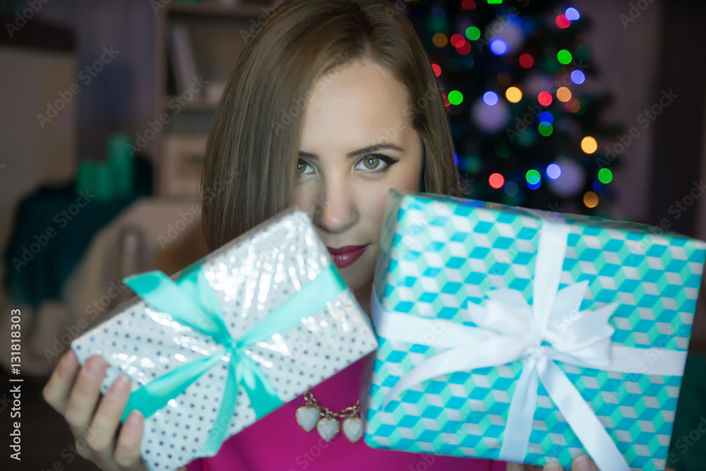 A girl with New Year gifts and christmas tree on the background. A girl with New Year gifts and christmas tree on the background.