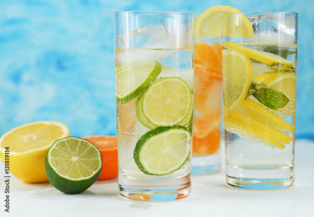 detox mineral water with lime, tangerine and lemon on a light background detox mineral water with lime, tangerine and lemon on a light background