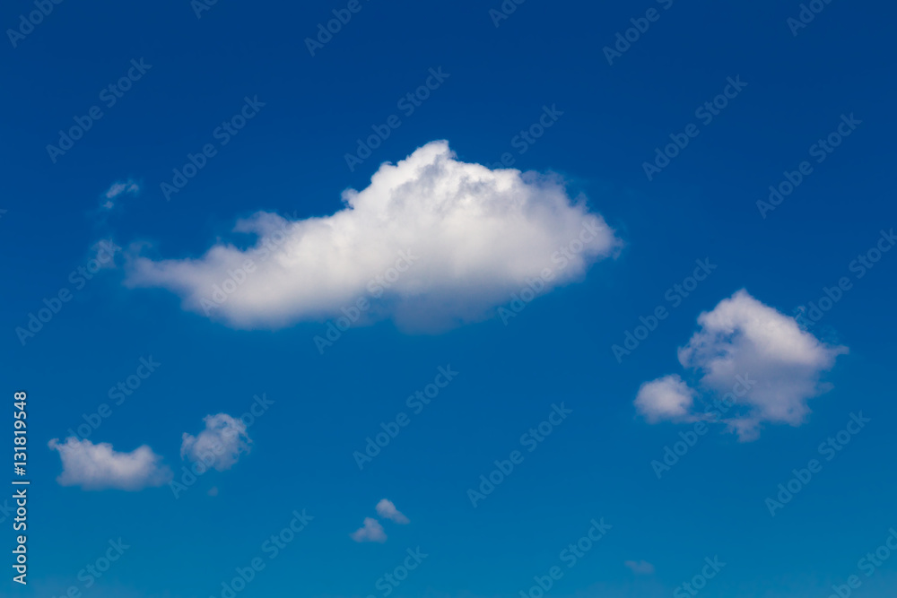 Fototapeta premium Fluffy white clouds against deep blue sky