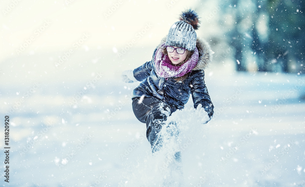 Young girl are playing with snow.Beauty Winter happy Girl Blowing Snow in frosty winter park or outdoors. Girl and winter cold weather. Young girl are playing with snow.Beauty Winter happy Girl Blowing Snow in frosty winter park or outdoors. Girl and winter cold weather.