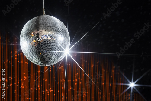Party disco ball with stars in nightclub with striped orange and black walls lit by spotlight, nightlife entertainment industry 