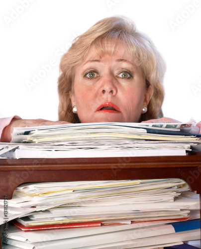 Foto Older woman uried by the large stack of paperwork