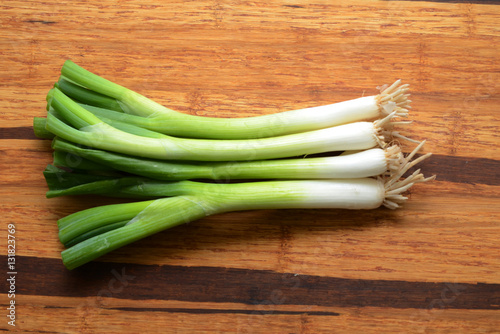 Sliced, chopped spring onions, salad onions, green onions or scallions on wood background