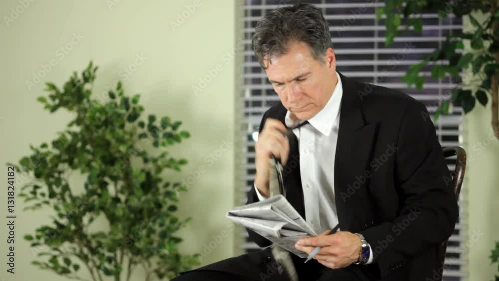 A mature man going through with a newspaper’s employment want ads. A mature man going through with a newspaper’s employment want ads.