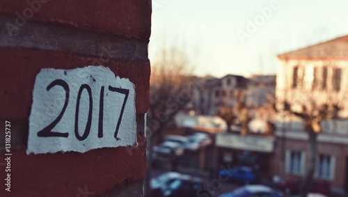 closeup of a piece of paper with the number 2017, as the new year, written in it, in a brick wall outdoors