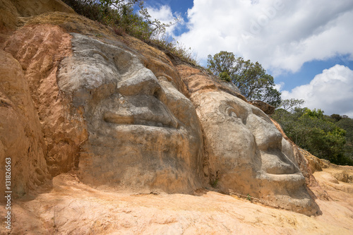 faces carved in the road side hill at the entrance of Silvia, Colombia