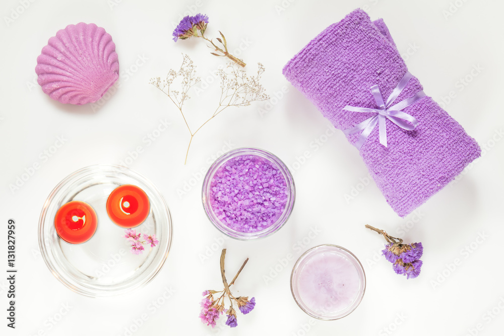 Spa products. Lavender bath salts, dry flowers, soap, cosmetic cream, light candles and towel. Violet purple concept. Flat lay on white background, top view. Spa products. Lavender bath salts, dry flowers, soap, cosmetic cream, light candles and towel. Violet purple concept. Flat lay on white background, top view.
