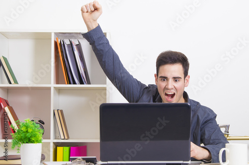 Fotografie male young celebrating with enthusiasm looking it computer laptop