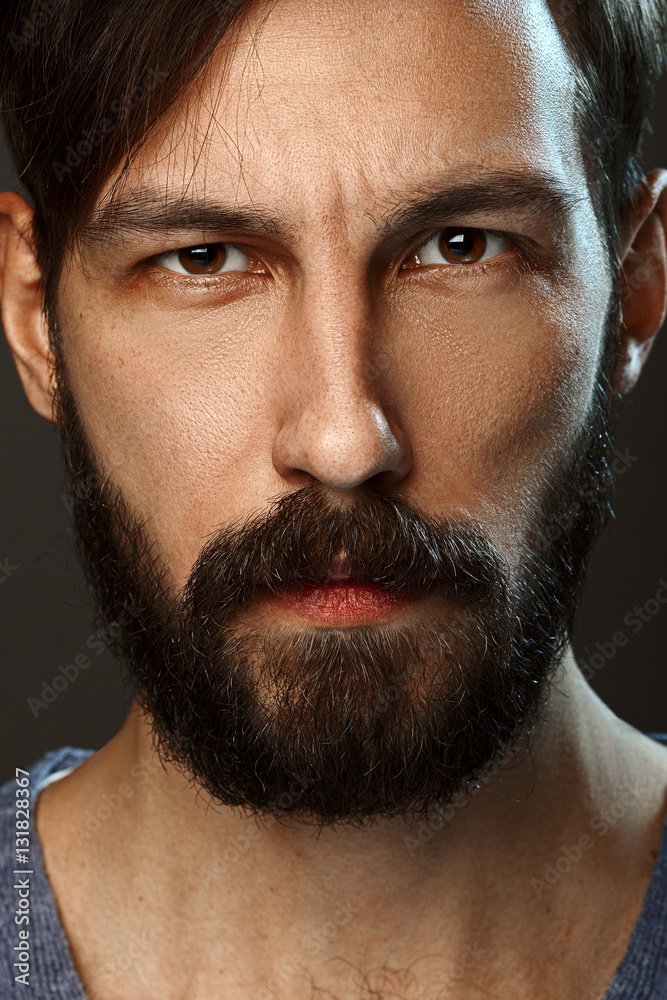 Obraz premium Closeup portrait of serious man with beard and mustache looking