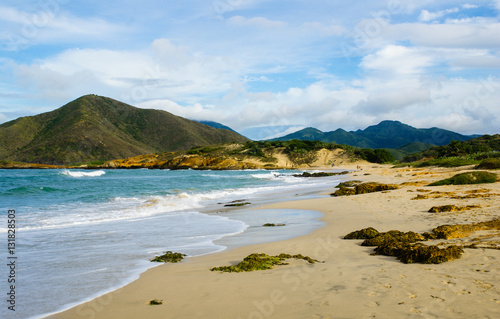 The shore of a beach with mountains in the background.