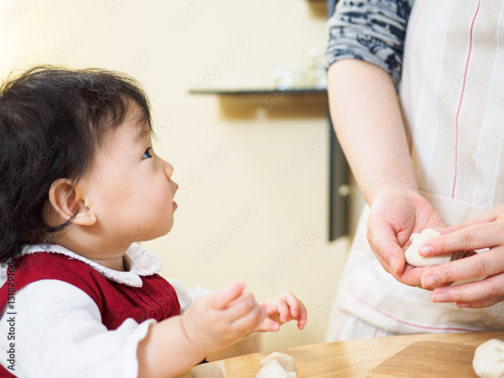 Adorable baby girl making gyoza with mom Adorable baby girl making gyoza with mom