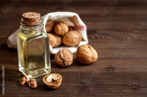 cosmetic and therapeutic walnut oil on dark wooden background