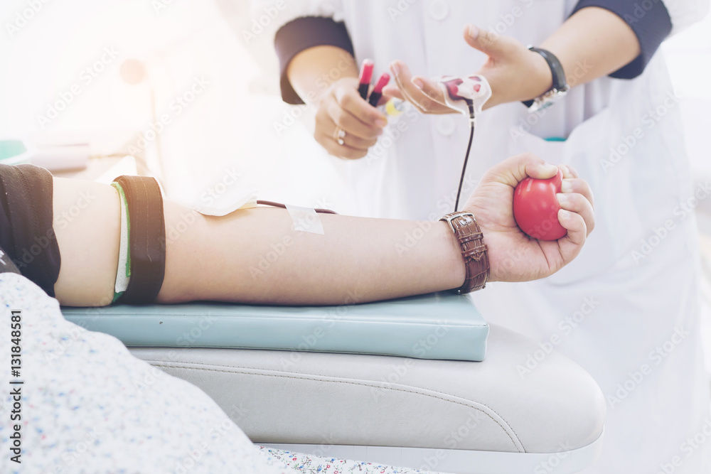 Fototapeta premium Blood donor at donation with a bouncy ball holding in hand.