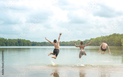 Young boy jumping into lake.
