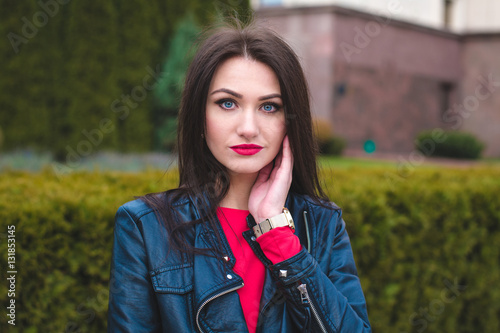 Autumn fashionable portrait of young happy brunette girl red lipstick outdoors in the city