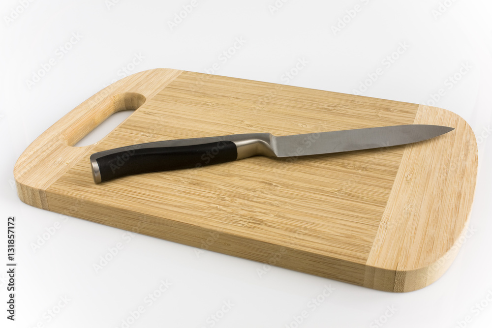 Cuttingboard with kitchen knife isolated on white background. Picture taken in studio with soft-box.