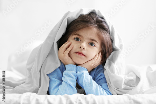 Cute little girl lying on b...