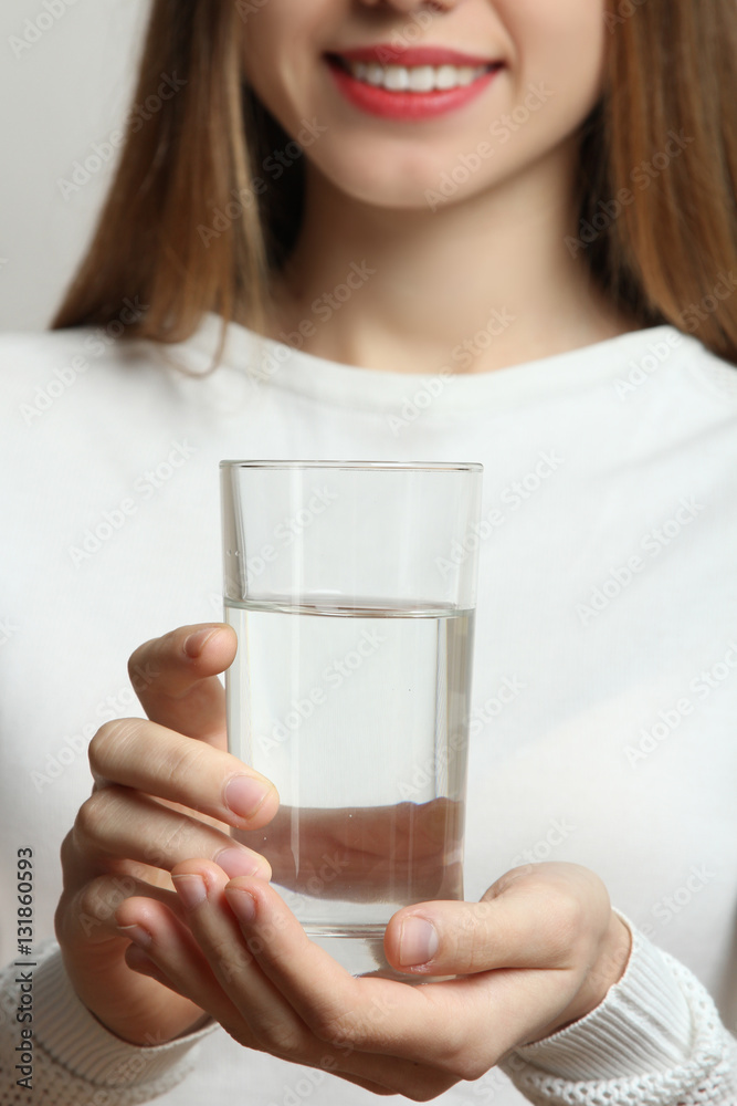 Female hand holding a glass of clean water, close-up. Female hand holding a glass of clean water, close-up.