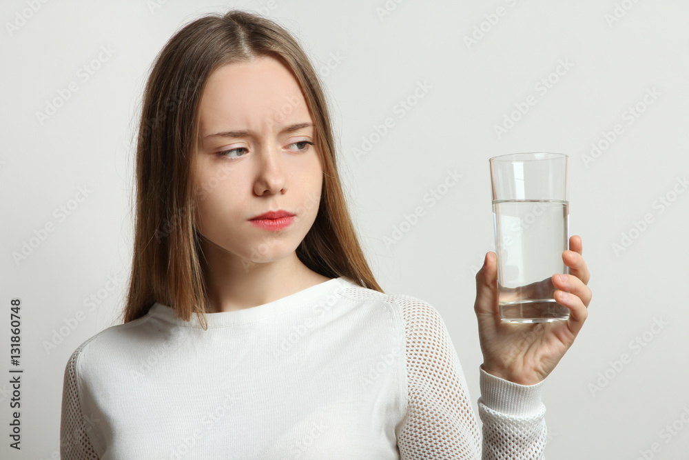 A young girl holding a glass of water. A young girl holding a glass of water.