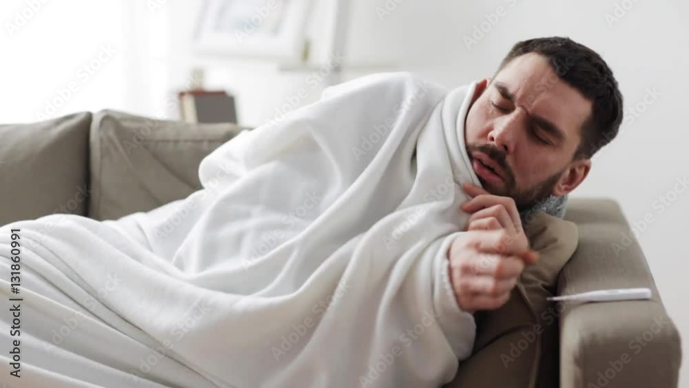 ill man with thermometer having flu at home ill man with thermometer having flu at home