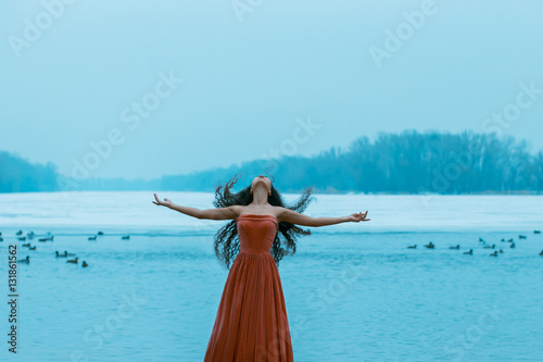 Foto Beautiful young brunette woman flies with the birds