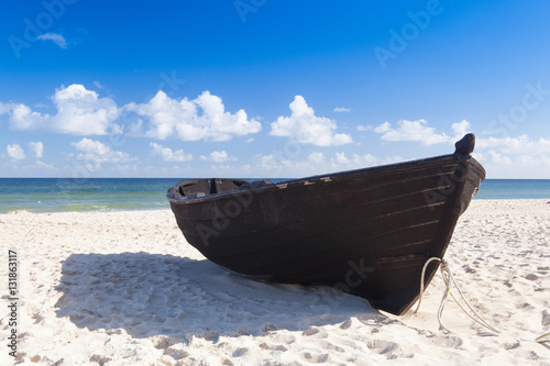 Old wooden fishing boat on the empty beach