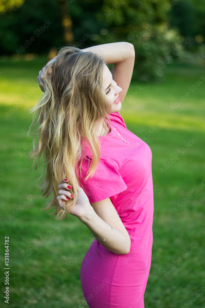 Portrait of a beautiful smiling young cute girl in a pink summer dress. Portrait of a beautiful smiling young cute girl in a pink summer dress.