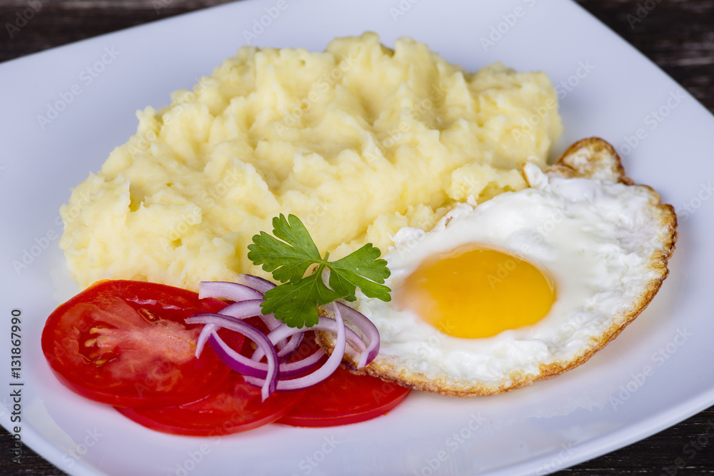 Mashed potatoes with fried eggs and tomato. Mashed potatoes with fried eggs and tomato.