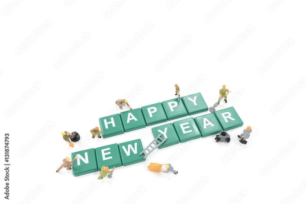 Miniature worker team building word happy new year on white back