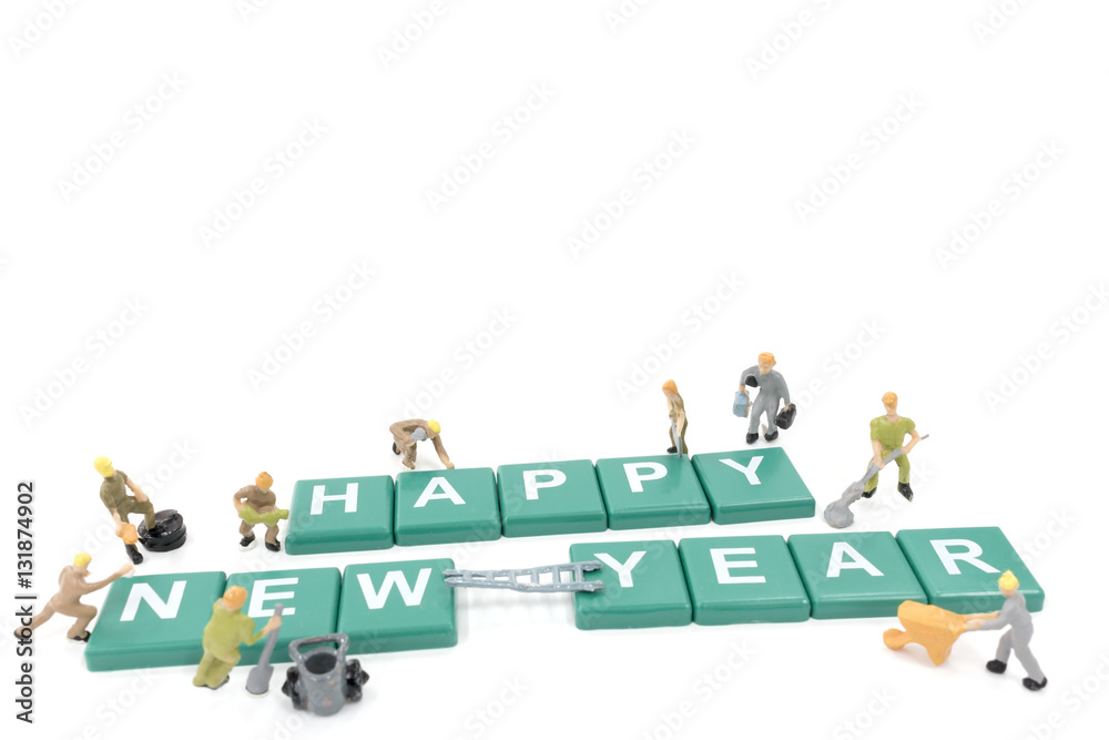 Miniature worker team building word happy new year on white background