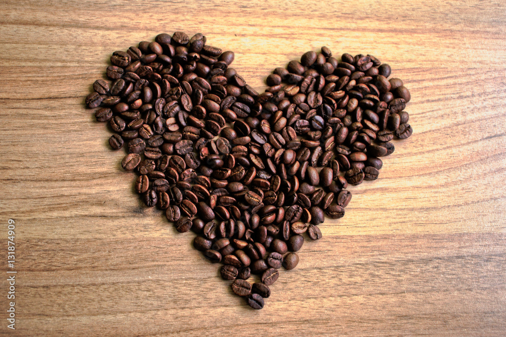 Coffee beans in a heart shape on a wooden table Coffee beans in a heart shape on a wooden table
